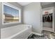 Main bathroom featuring a separate soaking tub, a window, and easy access to a walk-in closet at 2430 Redbud Meadow Ln, Douglasville, GA 30135