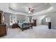 Spacious main bedroom with neutral paint, tray ceiling, ceiling fan, and ample closet space at 2430 Redbud Meadow Ln, Douglasville, GA 30135