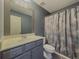 Well-lit bathroom featuring a vanity with a sink, a toilet, and a shower with a decorative curtain at 3318 Sardis Bend Dr, Buford, GA 30519