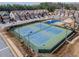 Aerial view of well-maintained tennis courts in a gated community with a basketball court and luxury townhomes at 3318 Sardis Bend Dr, Buford, GA 30519