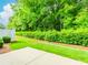 View of the backyard with a concrete patio and manicured lawn surrounded by tall, lush trees at 1555 Water Vista Ct # 4102, Cumming, GA 30041