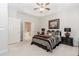 Cozy bedroom featuring a tray ceiling, ceiling fan, and ensuite bathroom at 1555 Water Vista Ct # 4102, Cumming, GA 30041