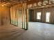 Unfinished basement featuring wood frame construction, concrete flooring, and a door leading outside at 2335 Portrush Way (Lot 26) Dr, Atlanta, GA 30339