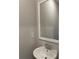 Small powder room featuring a white pedestal sink, chrome faucet, and a framed mirror against a neutral wall at 2335 Portrush Way (Lot 26) Dr, Atlanta, GA 30339
