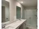 Bathroom with double sinks, white cabinets, and a glass-enclosed shower, offering a clean and modern aesthetic at 2335 Portrush Way (Lot 26) Dr, Atlanta, GA 30339