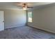 Cozy bedroom features carpet flooring, a ceiling fan, a large window, and a neutral paint palette at 2335 Portrush Way (Lot 26) Dr, Atlanta, GA 30339