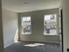 Bright bedroom with neutral walls, carpet and two large windows overlooking neighborhood homes at 2335 Portrush Way (Lot 26) Dr, Atlanta, GA 30339