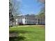 A white building surrounded by a large green lawn and trees at 2335 Portrush Way (Lot 26) Dr, Atlanta, GA 30339