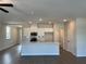 Open-concept kitchen features white cabinets, stainless appliances, and an island with a sink and countertop seating at 2335 Portrush Way (Lot 26) Dr, Atlanta, GA 30339