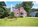 Charming two-story red brick home with blue shutters, surrounded by a lush green lawn and mature trees at 3161 Pagoda Trce, Lawrenceville, GA 30043