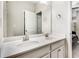 Elegant bathroom featuring double sinks with white cabinetry, a large mirror, and a glimpse into the bedroom at 4831 Miller Hill Rd, Buford, GA 30518
