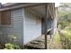 Exterior view of a neglected property with boarded windows and overgrown landscaping at 108 Vine Sw St, Atlanta, GA 30314