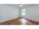 This bedroom has hardwood floors, a lighted ceiling fan and a single window at 307 Berkeley Woods Dr, Duluth, GA 30096