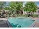 Community swimming pool surrounded by lush greenery, lounge chairs and residential buildings at 307 Berkeley Woods Dr, Duluth, GA 30096
