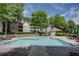 Community pool with lounge chairs surrounded by landscaped greenery and beautiful condos at 307 Berkeley Woods Dr, Duluth, GA 30096