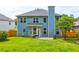Exterior view of blue two-story home featuring large grassy backyard with wooden fence at 133 Parkway Dr, Fairburn, GA 30213