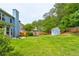 Large backyard with a shed, green lawn, and plenty of shade trees at 133 Parkway Dr, Fairburn, GA 30213
