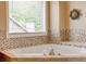 A luxurious bathtub with tile surround and a large window view at 133 Parkway Dr, Fairburn, GA 30213