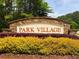 Stone community sign for Park Village surrounded by manicured landscaping at 133 Parkway Dr, Fairburn, GA 30213