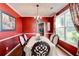 Elegant dining room with striking red walls, a decorative chandelier, and a large window at 133 Parkway Dr, Fairburn, GA 30213