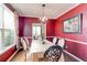 Chic dining room featuring a chandelier, bold red walls, and a window with decorative curtains, perfect for hosting gatherings at 133 Parkway Dr, Fairburn, GA 30213