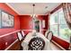 Elegant dining room with red walls, a chandelier, and a large window with decorative curtains at 133 Parkway Dr, Fairburn, GA 30213