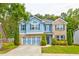 Charming two-story home with a blue exterior, brick accents, a well-manicured lawn, and a two-car garage at 133 Parkway Dr, Fairburn, GA 30213