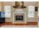 Close up of fireplace with decorative mantel and vases of flowers, flanked by bright, windowed walls at 133 Parkway Dr, Fairburn, GA 30213