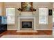 Cozy living room featuring a fireplace, hardwood floors, and natural light, perfect for relaxing and entertaining guests at 133 Parkway Dr, Fairburn, GA 30213