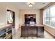 Home office with a large wooden desk and a hutch, complemented by natural light from a large window at 133 Parkway Dr, Fairburn, GA 30213