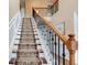 Grand staircase showcasing carpeted steps, wooden handrail, and iron balusters, adding sophistication to the home's interior at 133 Parkway Dr, Fairburn, GA 30213