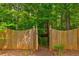 Gated treehouse nestled among lush greenery with wooden stairs leading up at 133 Parkway Dr, Fairburn, GA 30213