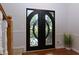 Elegant arched double doors with ornate metalwork and glass panels, opening to a bright foyer at 2995 Aspen Ridge Ct, Snellville, GA 30078