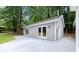 Backyard showing the exterior of a gray outbuilding with white trim, concrete, and a well-maintained lawn at 4504 Reva Ne Way, Marietta, GA 30066