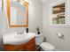 A charming bathroom featuring a wood vanity with a white sink, complemented by natural light from the window at 4504 Reva Ne Way, Marietta, GA 30066
