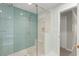 Sleek walk-in shower with glass enclosure, featuring blue tiling, a built-in bench, and a showerhead at 4504 Reva Ne Way, Marietta, GA 30066