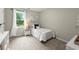 A cozy bedroom showcasing natural light with a bedside table, a single bed, and neutral carpeting at 4504 Reva Ne Way, Marietta, GA 30066