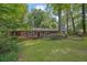 Traditional-style home featuring a brick facade, red shutters, and a green lawn, nestled among mature trees at 1981 Bramblewood Ne Dr, Brookhaven, GA 30329