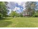 Spacious green backyard with outbuildings and mature trees at 218 Ward Rd, Ellenwood, GA 30294
