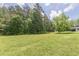 Expansive green lawn with mature trees in the backyard at 218 Ward Rd, Ellenwood, GA 30294