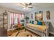 Bedroom featuring a ceiling fan, daybed, large window, and an adjacent workspace at 218 Ward Rd, Ellenwood, GA 30294