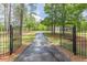 View of gated driveway leading to a home surrounded by trees, offering privacy and curb appeal at 218 Ward Rd, Ellenwood, GA 30294