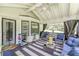 Relaxing covered back porch featuring comfortable seating and black and white striped outdoor rug at 218 Ward Rd, Ellenwood, GA 30294