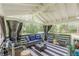 Relaxing covered back porch featuring comfortable seating and black and white striped outdoor rug at 218 Ward Rd, Ellenwood, GA 30294