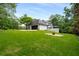 Expansive backyard with lush lawn, mature trees, fire pit and view of home's exterior at 2912 Vinings Forest Se Way, Atlanta, GA 30339