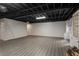 Large basement with exposed ceiling, built-in shelving, and modern laminate floors at 2912 Vinings Forest Se Way, Atlanta, GA 30339