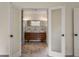 Bathroom with double sinks, wood vanity, tile floors and contemporary lighting at 2912 Vinings Forest Se Way, Atlanta, GA 30339