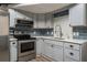 Modern kitchen features grey cabinets, stainless steel appliances, a white countertop and blue backsplash at 2912 Vinings Forest Se Way, Atlanta, GA 30339