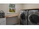 Laundry room featuring modern appliances, a sink, and natural light streaming through a window with view of outdoor foliage at 2912 Vinings Forest Se Way, Atlanta, GA 30339