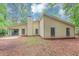 Exterior of home featuring wood siding, a brick chimney, patio and mature trees at 6350 Mozart Dr, Riverdale, GA 30296